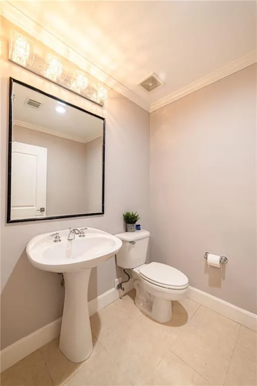 Bathroom featuring ornamental molding and tile patterned flooring