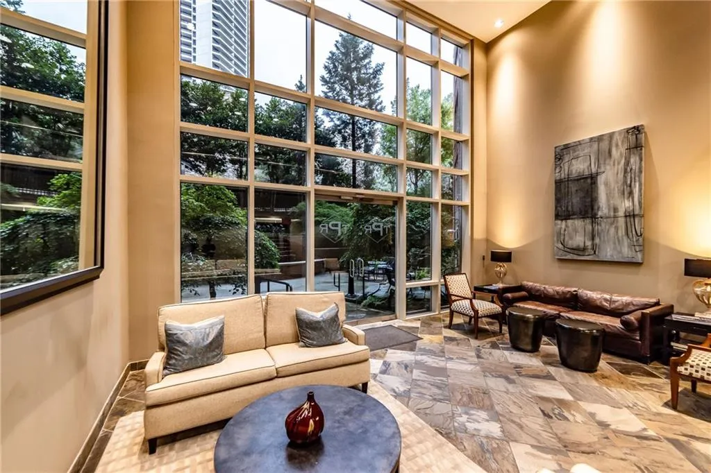 Living area with a towering ceiling and floor to ceiling windows
