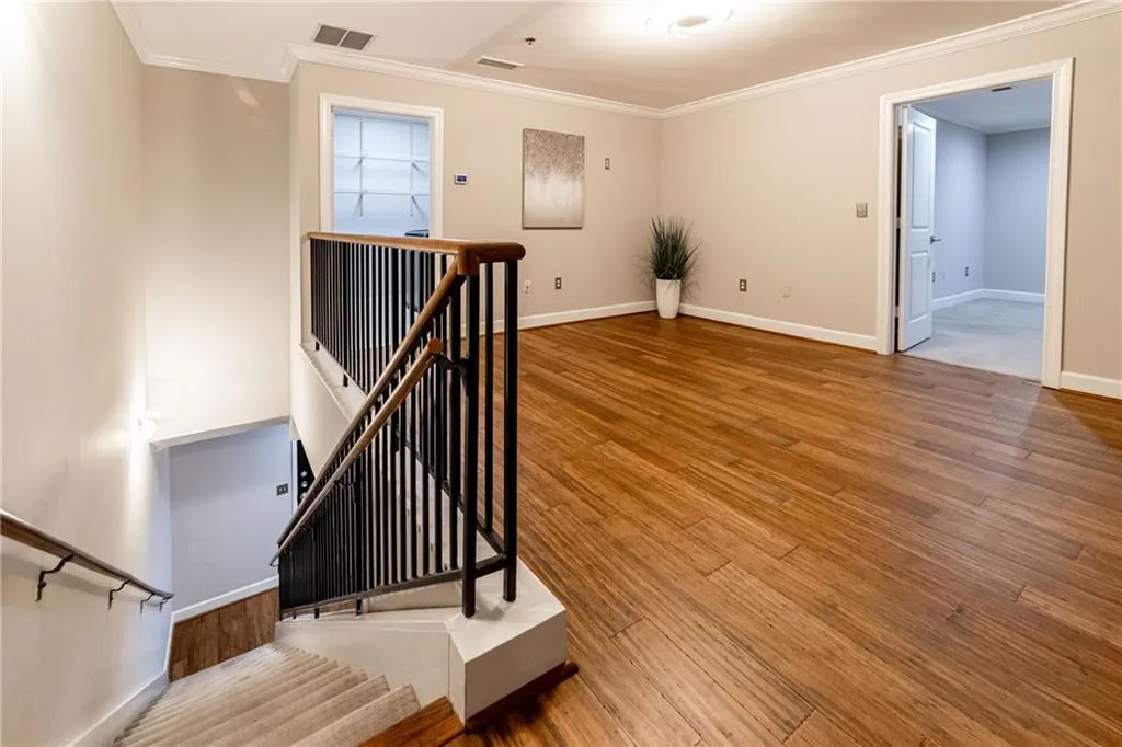 Stairway featuring crown molding and wood finished floors