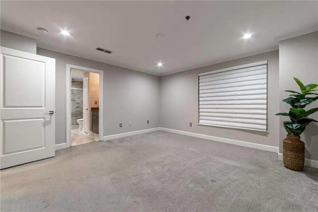 Spare room featuring light colored carpet, recessed lighting, fire sprinkler in ceiling, a smoke detector, and ornamental molding