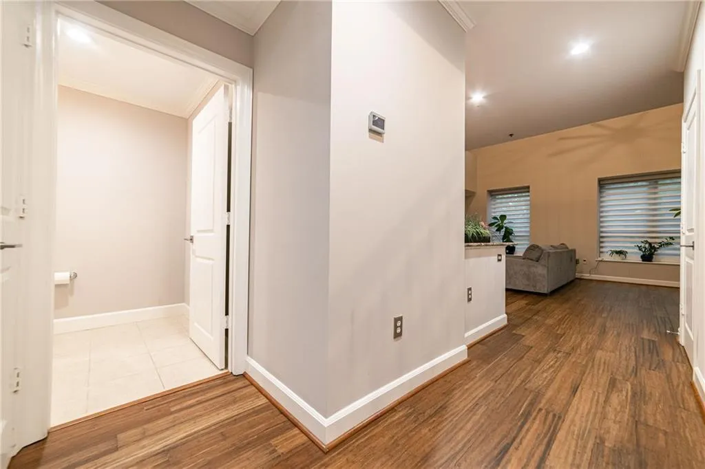 Corridor featuring ornamental molding, wood finished floors, and recessed lighting