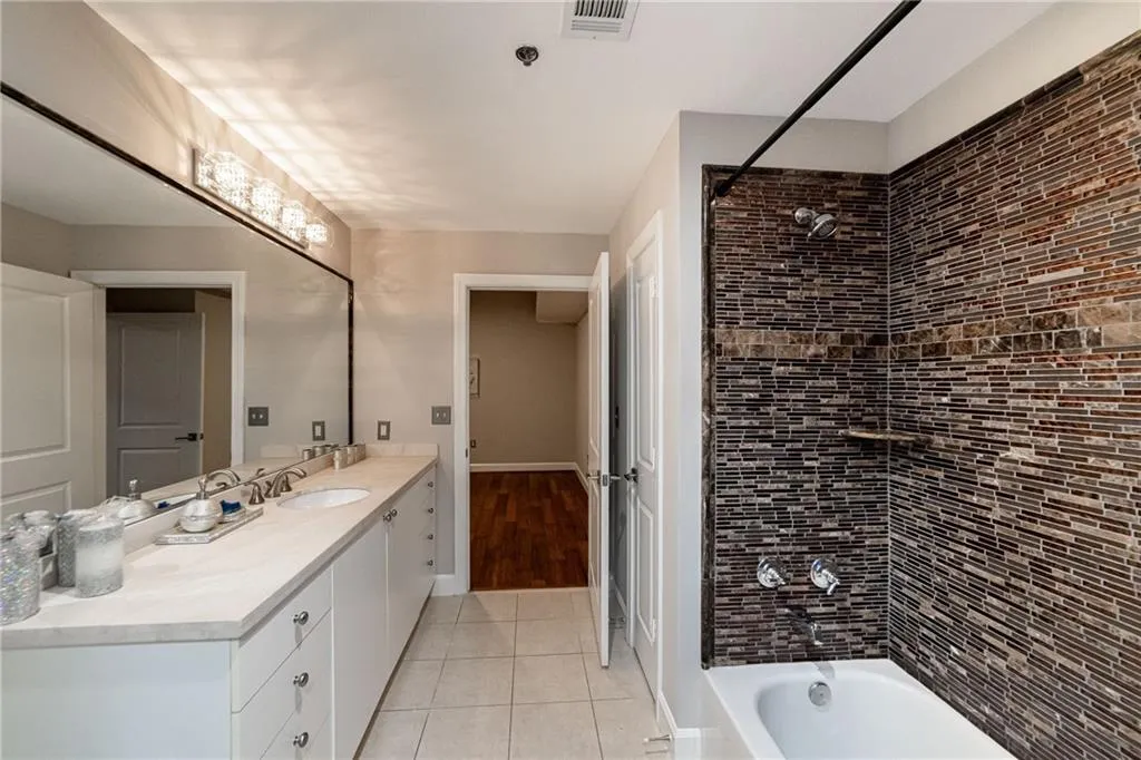 Bathroom featuring vanity, tile patterned flooring, and bathing tub / shower combination