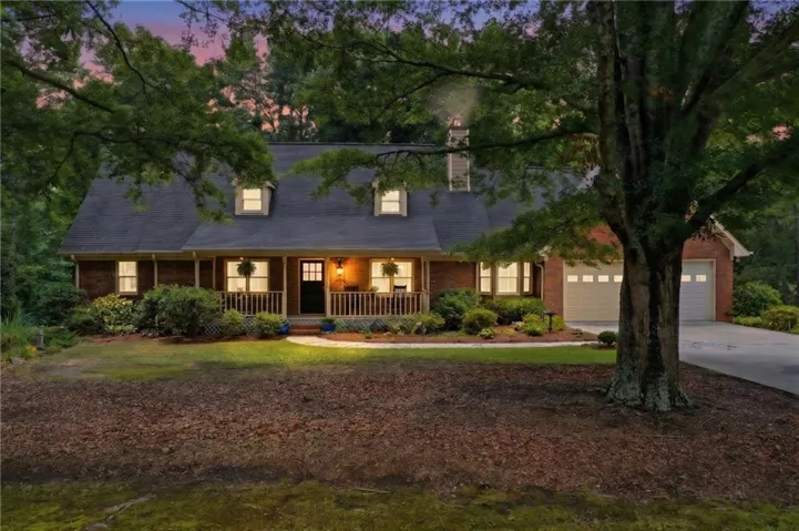 Brick exterior with gabled dormers, an inviting front porch, and an attached two-car garage