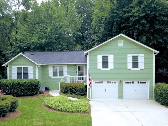 Light green siding with white trim and a dark shingle roof