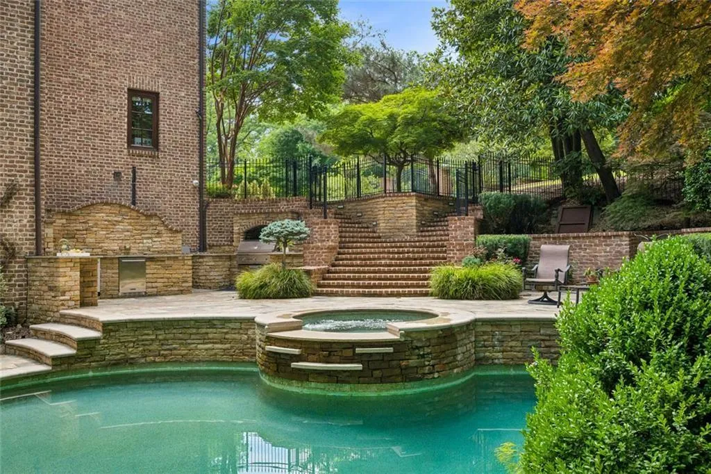 A custom built outdoor kitchen, handcrafted brickwork, stone spa, and meticulously designed landscaping — this backyard is an entertainer’s paradise from every angle.