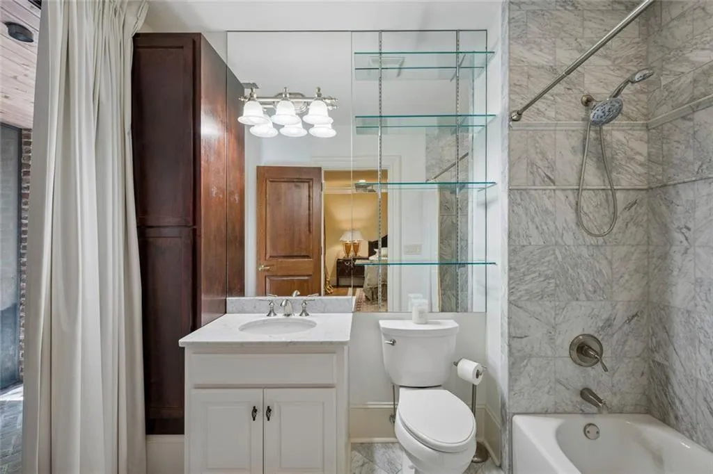 The terrace level bathroom is beautifully finished with marble tile, a glass shower, soaking tub, and custom cabinetry.