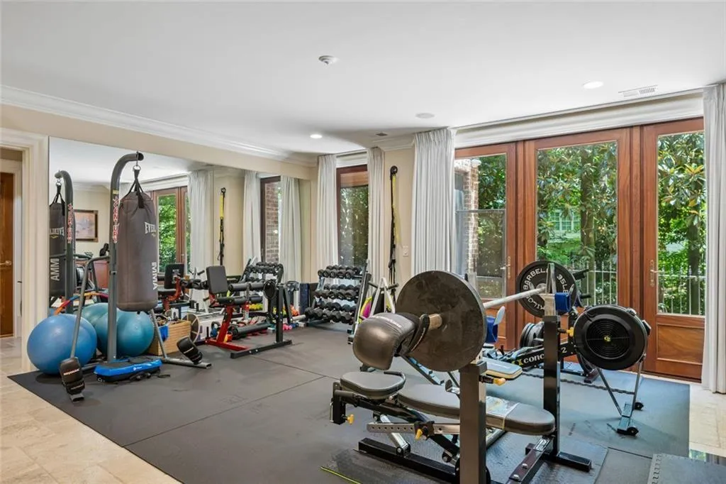 The terrace level offers endless possibilities — currently set up as a fully equipped private gym with French doors opening to the garden, this expansive space can effortlessly transform into the ultimate entertainment room, game room, or anything you envision.