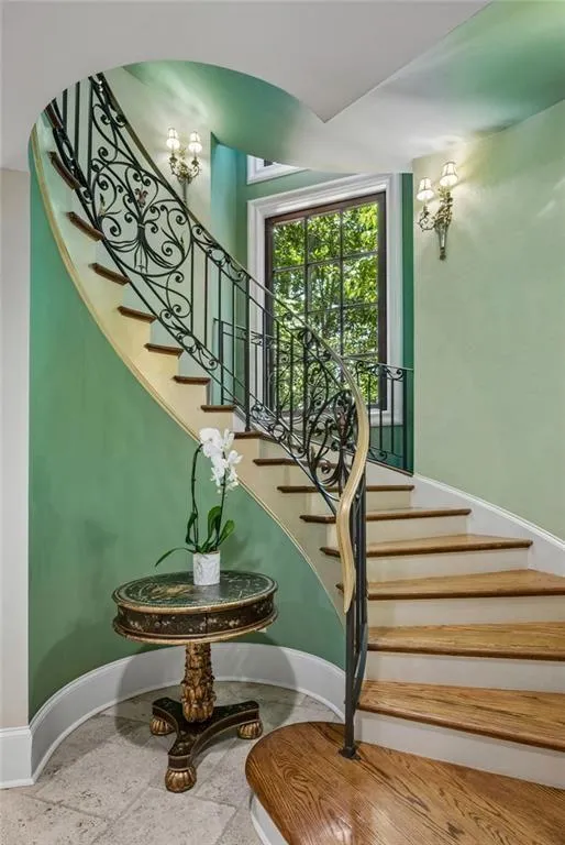 The staircase gracefully sweeps down to the lower level.