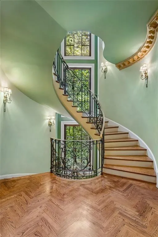 Sweeping spiral Staircase with custom wrought iron railings.