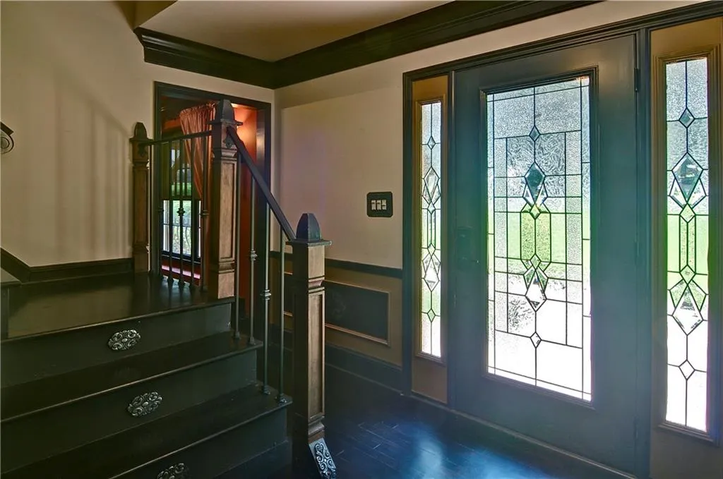 Foyer with stairway, hardwood flooring, and crown molding