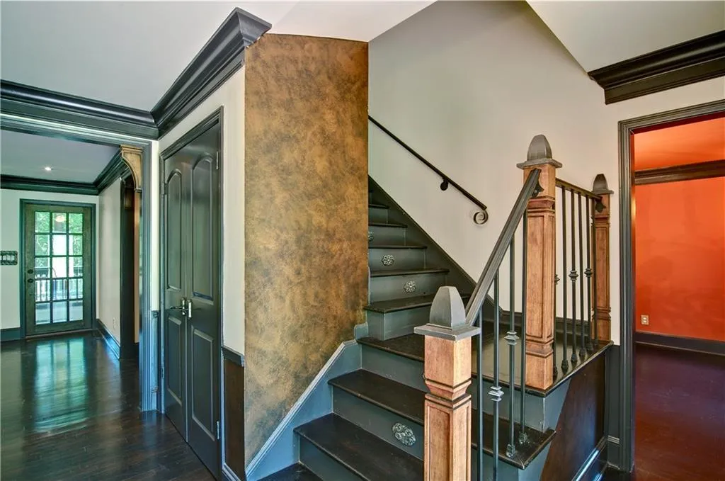 Staircase with crown molding and hardwood floors