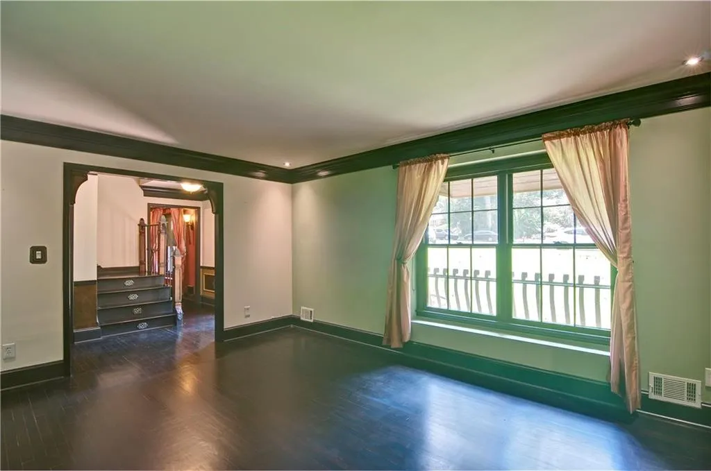 Living room featuring crown molding, hardwood floors, and a big beautiful window to let the light in