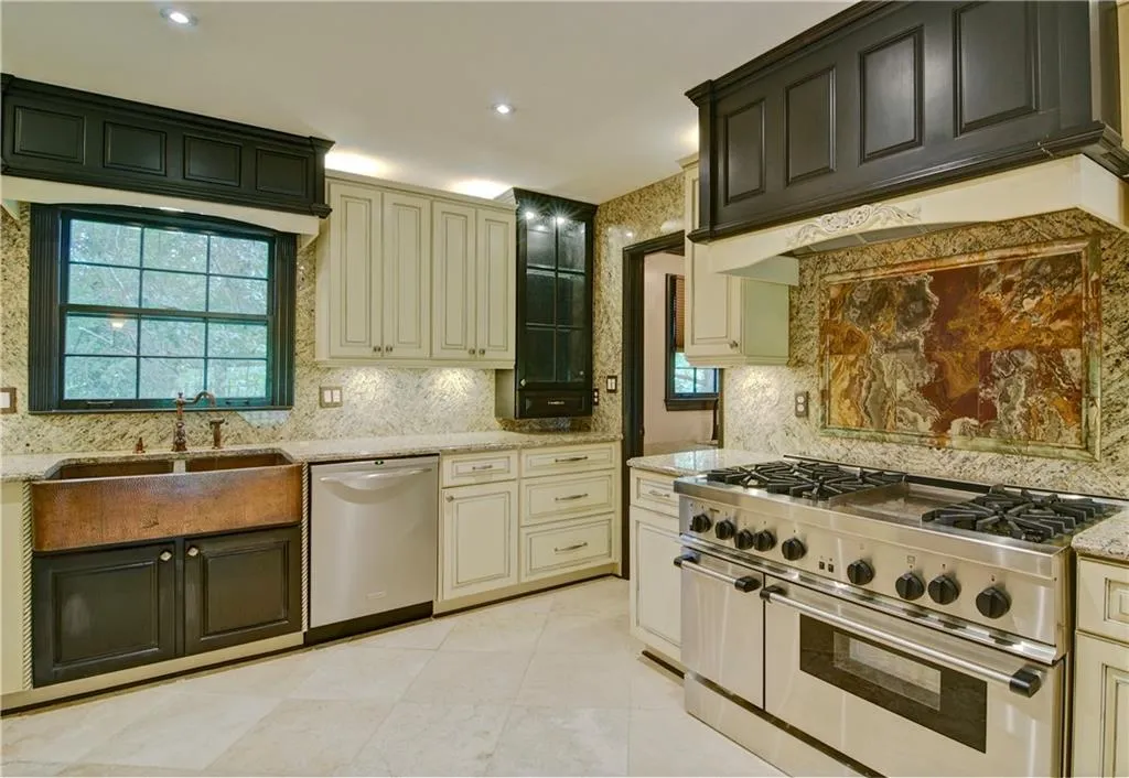Kitchen features stainless steel appliances, granite counters, decorative backsplash, and custom exhaust hood