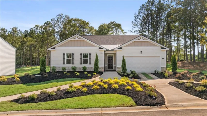 Craftsman-style home featuring board and batten siding, roof with shingles, and brick siding