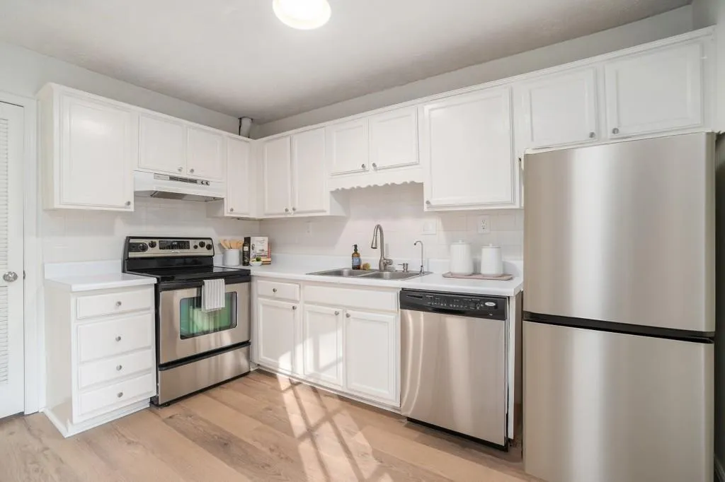 The spacious Kitchen offers White Cabinetry, Stainless Steel Appliances, Ample Storage, and a Timeless White Backsplash.