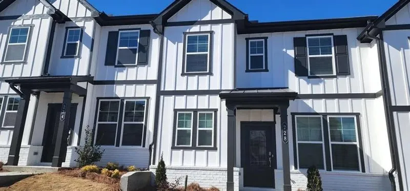 View of front of house featuring board and batten siding and brick siding