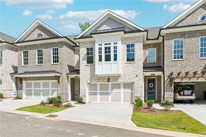 Brick exterior with a gabled roofline, bay window, and attached garage