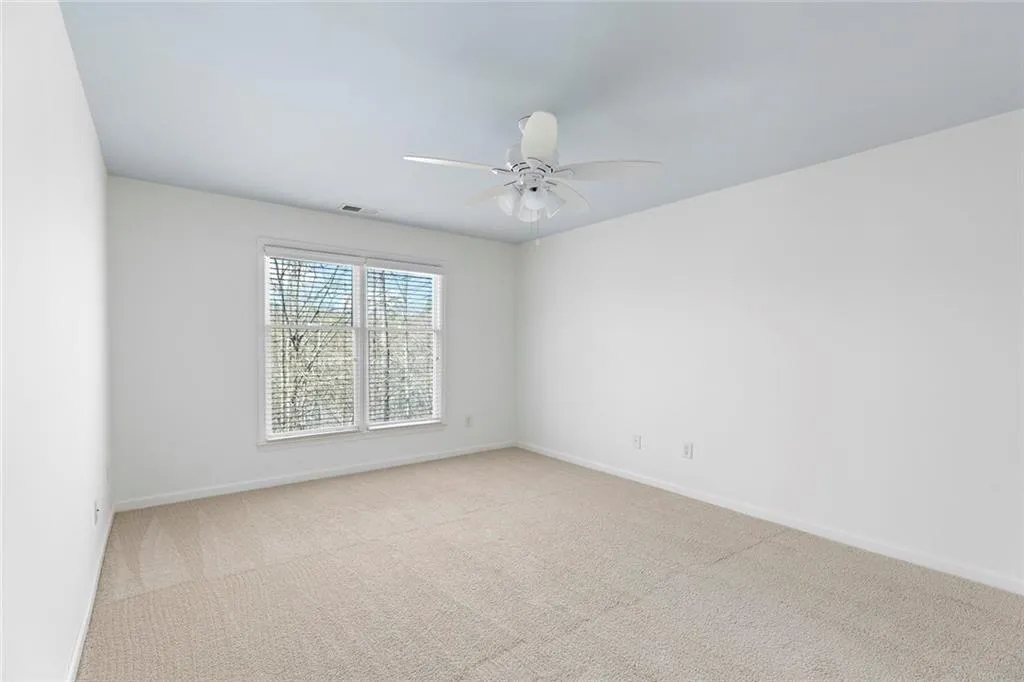 oversized primary bedroom with views of wooded area