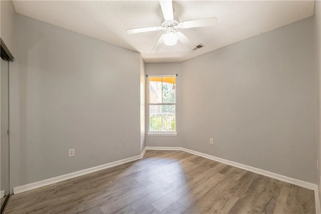 Unfurnished room with wood finished floors, a textured ceiling, and ceiling fan