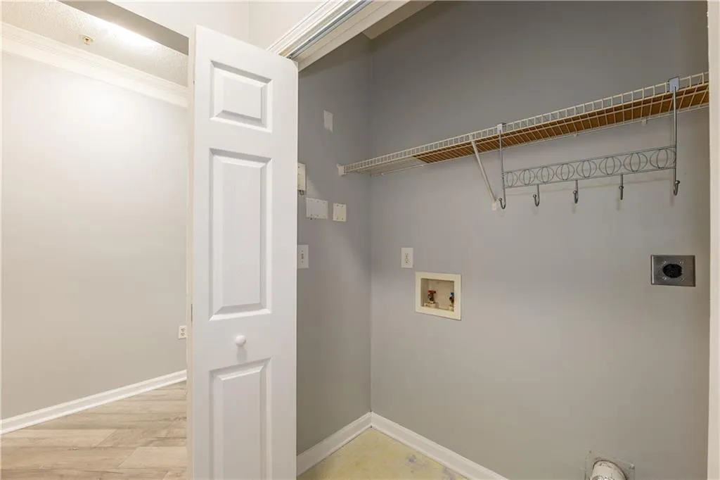 Laundry area featuring electric dryer hookup, washer hookup, light wood-style floors, and ornamental molding