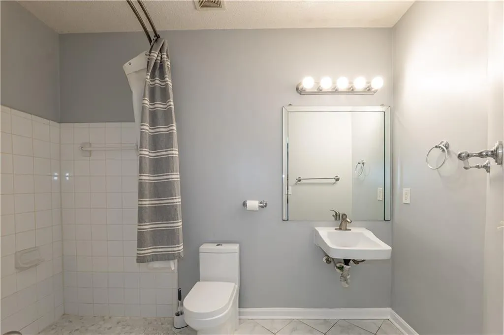 Full bath with a tile shower and marble finish flooring