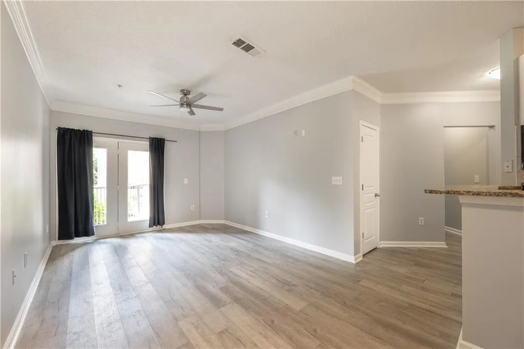 Spare room featuring a ceiling fan, ornamental molding, and wood finished floors