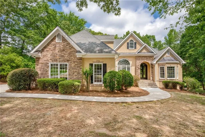 Stucco and stone exterior with multiple gables and dormer windows