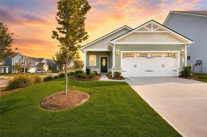 Single-story residence featuring green siding with light-colored shake accents and a black front door with an oval window