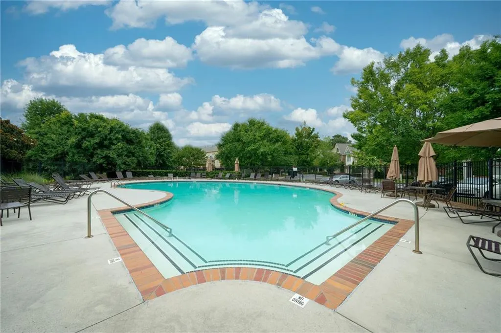 View of one of two swimming pools with a patio area