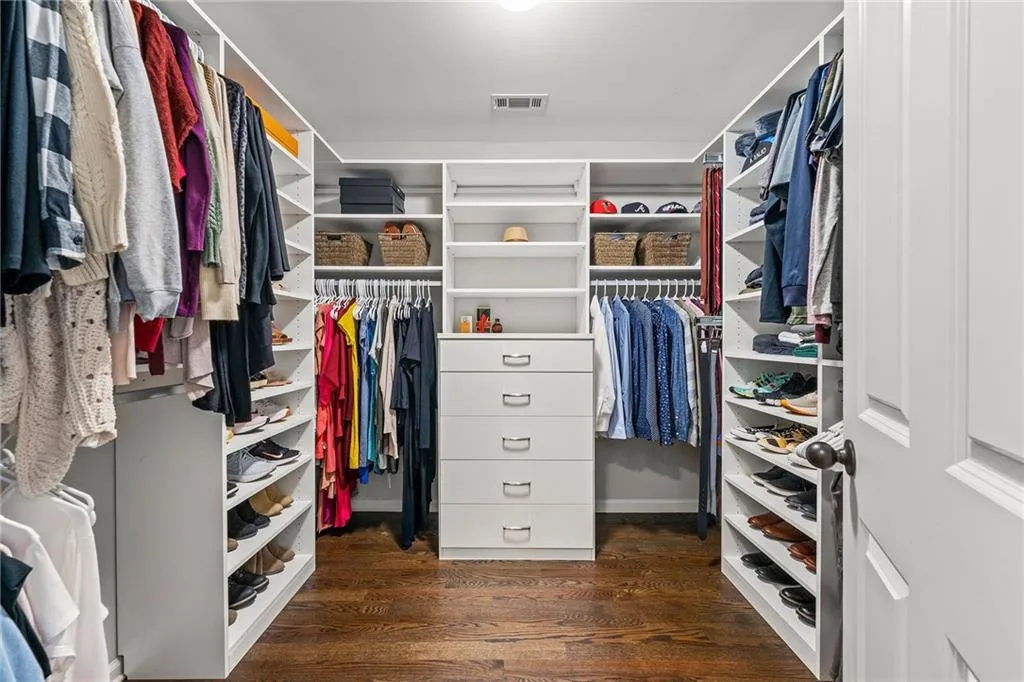Walk in closet with dark wood-type flooring