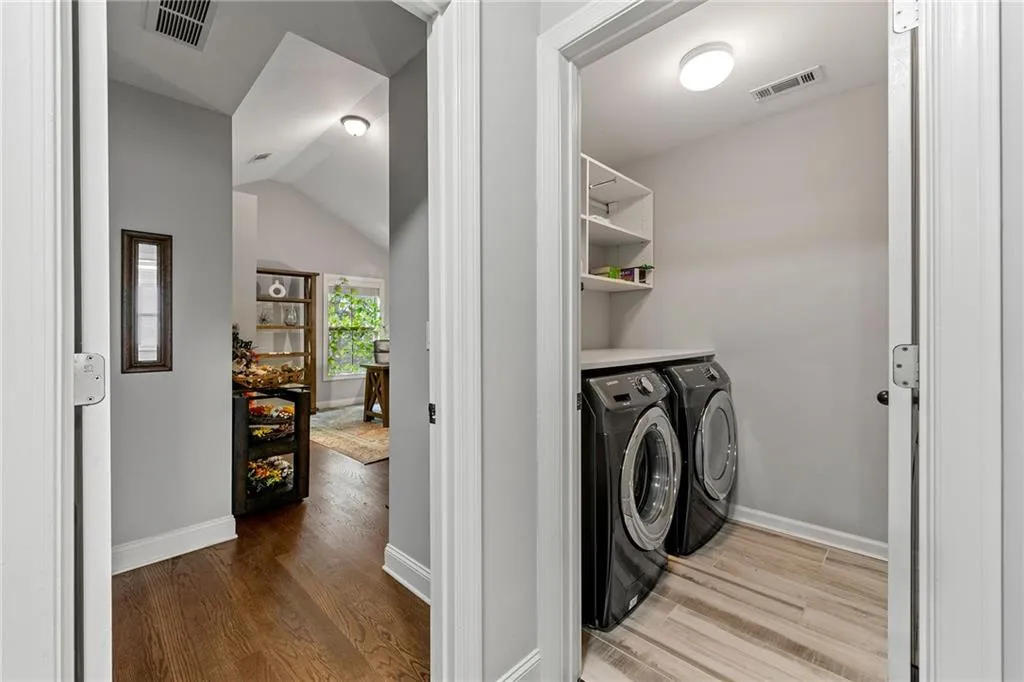 Laundry room featuring washing machine and clothes dryer and hardwood / wood-style flooring