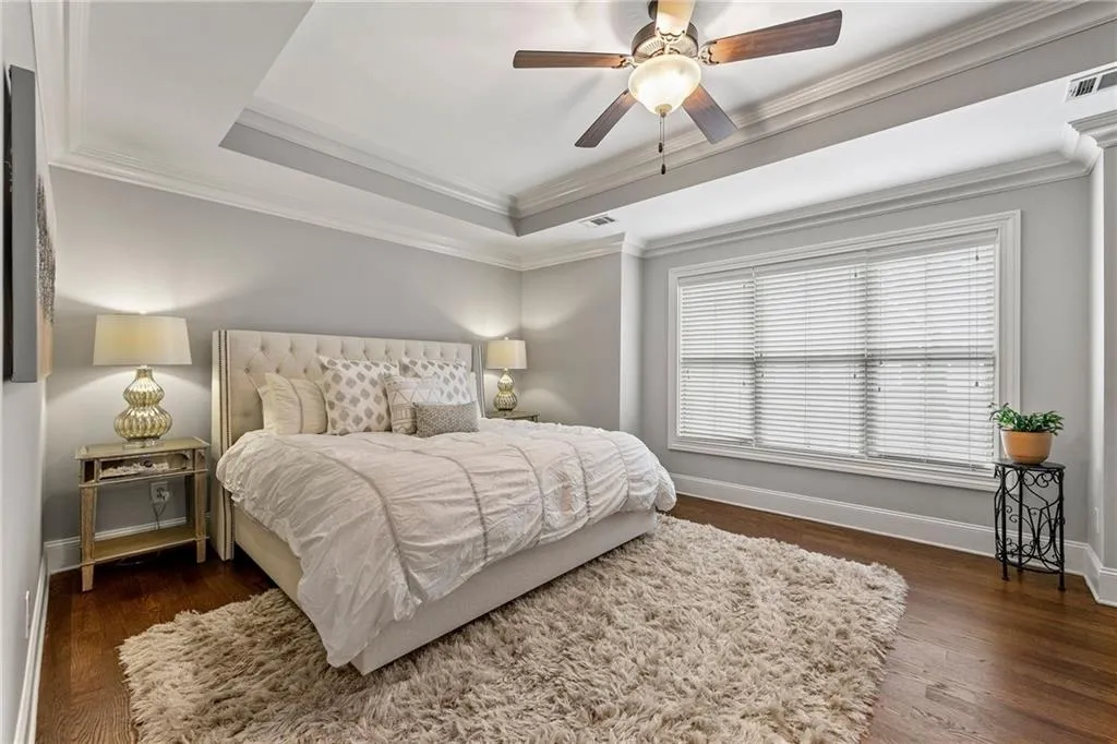 Bedroom with ceiling fan, crown molding, and dark hardwood / wood-style flooring