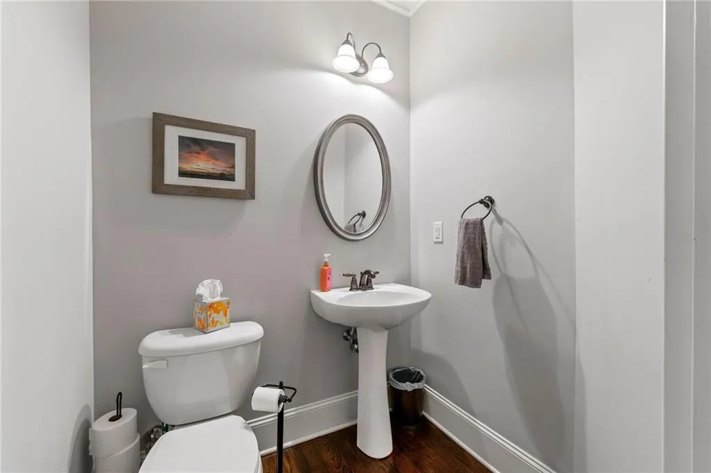Bathroom featuring wood-type flooring, toilet, and sink
