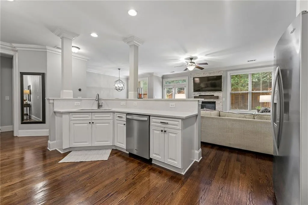Kitchen with stainless steel appliances, dark hardwood / wood-style floors, sink, and white cabinetry