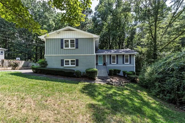 Two-story exterior with two-tone siding, contrasting shutters, and a prominent front entrance with steps