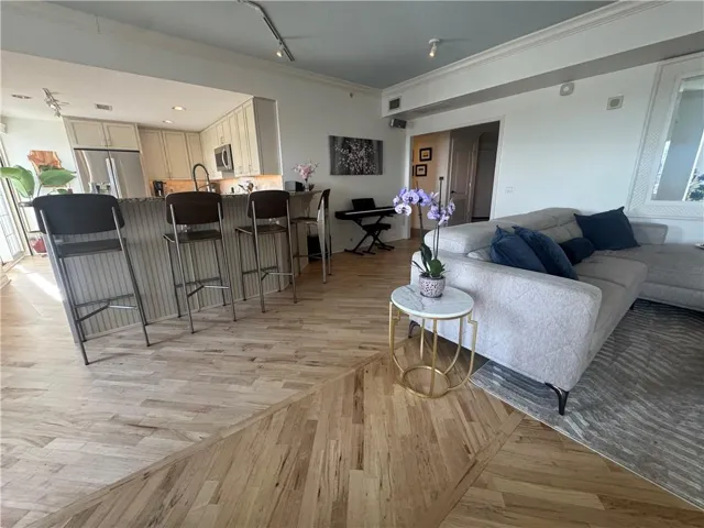 Open-concept living area featuring light wood-finish flooring with a distinctive pattern