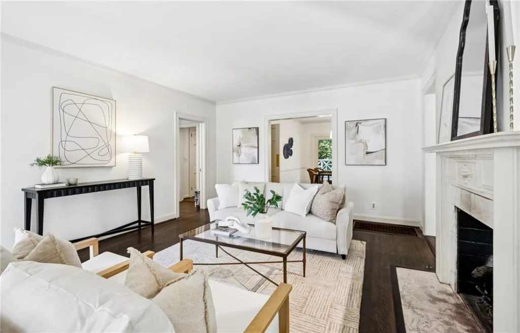 Living area with ornamental molding, wood finished floors, and a high end fireplace