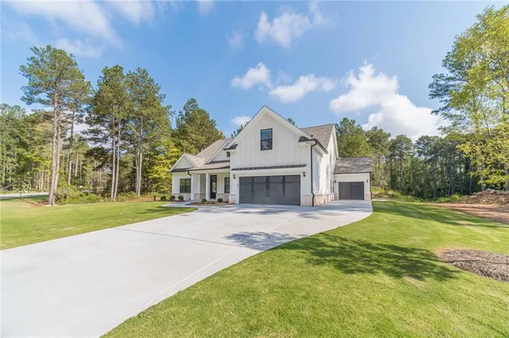 Modern farmhouse exterior with white vertical siding and dark-framed windows