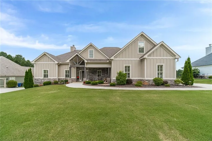 Craftsman-style exterior with board and batten siding, stone accents, covered entry, and pitched rooflines