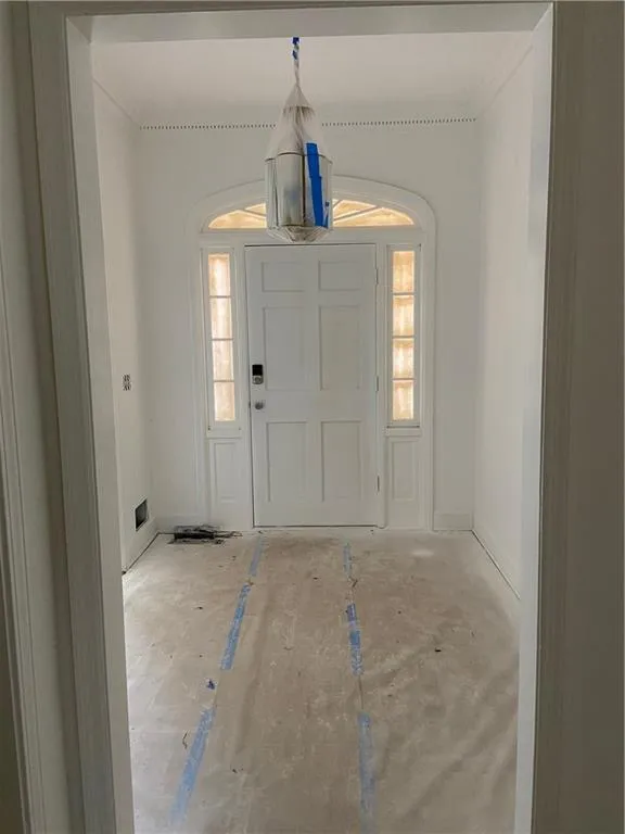 Entryway featuring plenty of natural light and crown molding