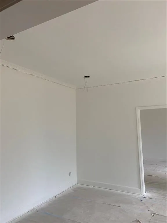 Unfurnished room with concrete flooring and ornamental molding
