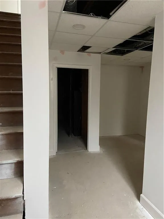 Basement with stairs and a drop ceiling