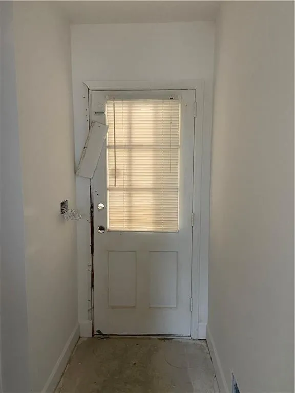 Doorway to garage featuring baseboards
