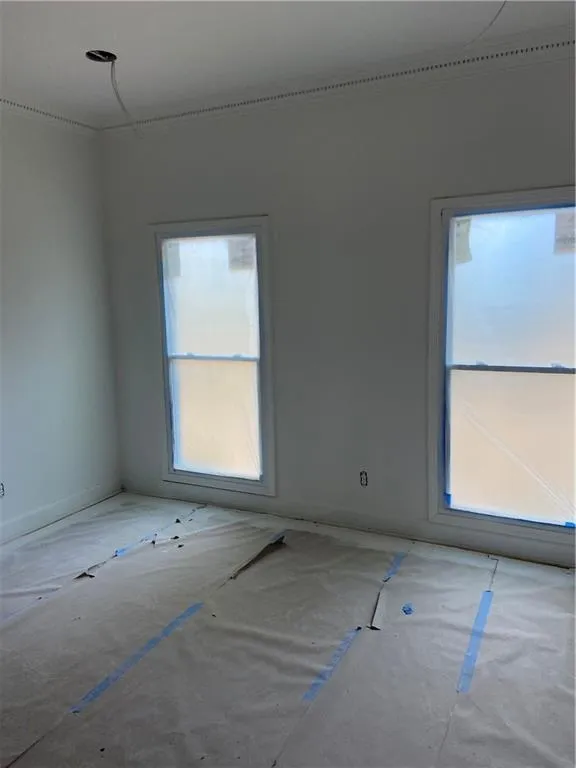 Unfurnished room with ornamental molding and baseboards