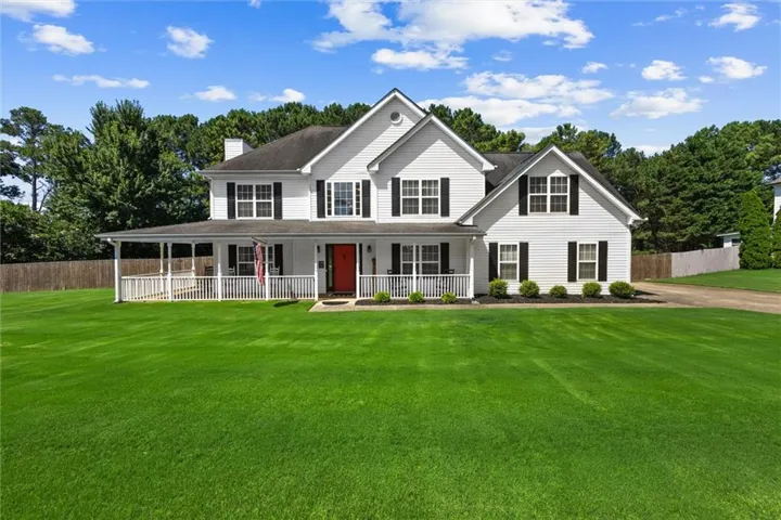 White siding exterior with black shutters and a prominent red front door