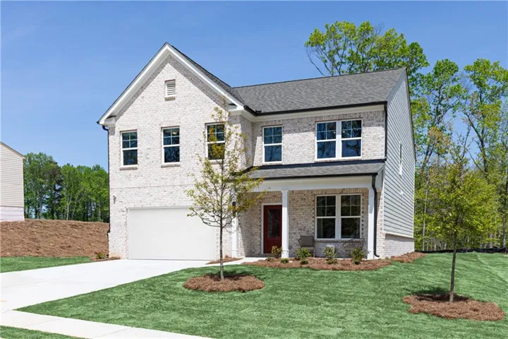 View of front of home featuring an attached garage, brick siding, a front lawn, covered porch, and driveway
