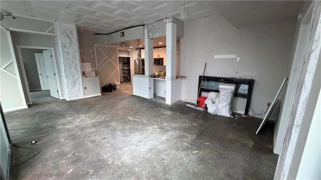 Unfurnished living room featuring unfinished concrete floors