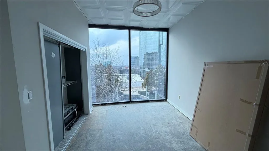 Unfurnished living room featuring floor to ceiling windows, a city view, and an ornate ceiling
