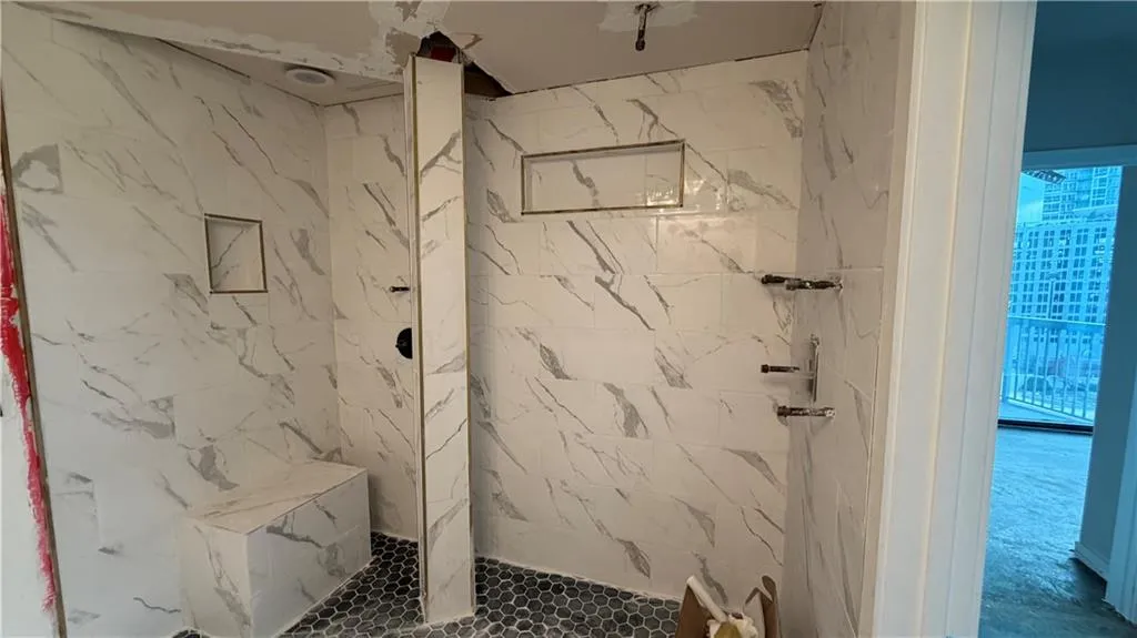 Full bathroom with a marble finish shower