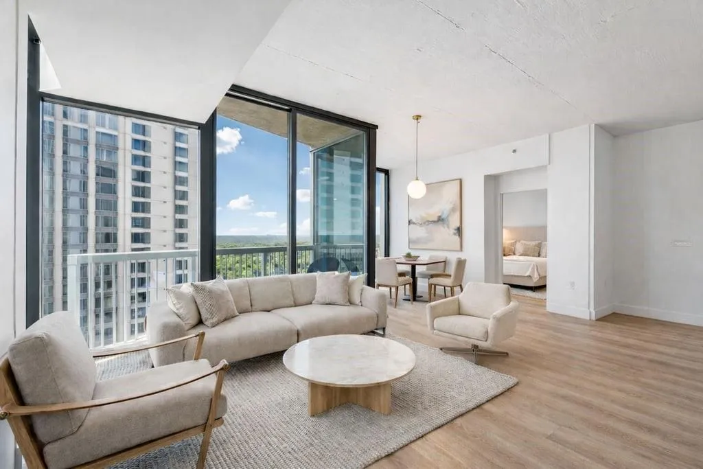Living room with a wall of windows, wood finished floors, and a view of city
